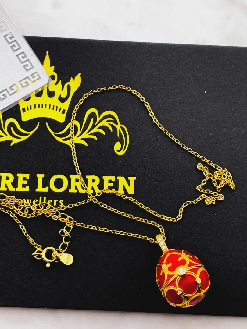 The Pierre Lorren Silver Faberge egg is a handcrafted piece featuring a red design. It showcases intricate detailing, typical of Faberge-style artistry. If you have specific questions about it or need more information, feel free to ask!